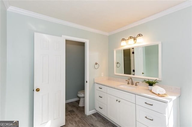 bathroom featuring ornamental molding, vanity, toilet, and wood finished floors