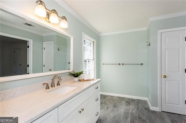 bathroom with crown molding, vanity, baseboards, and wood finished floors