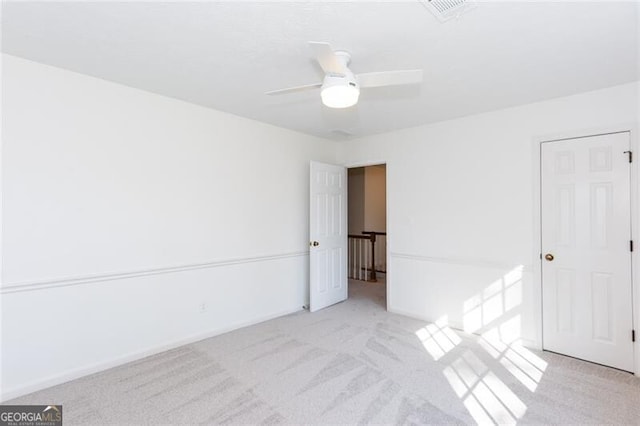 unfurnished bedroom featuring carpet, visible vents, and a ceiling fan