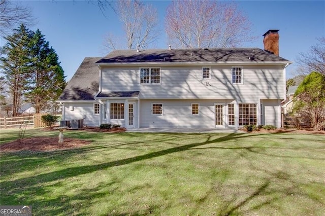 back of property with french doors, a patio, a chimney, a lawn, and fence