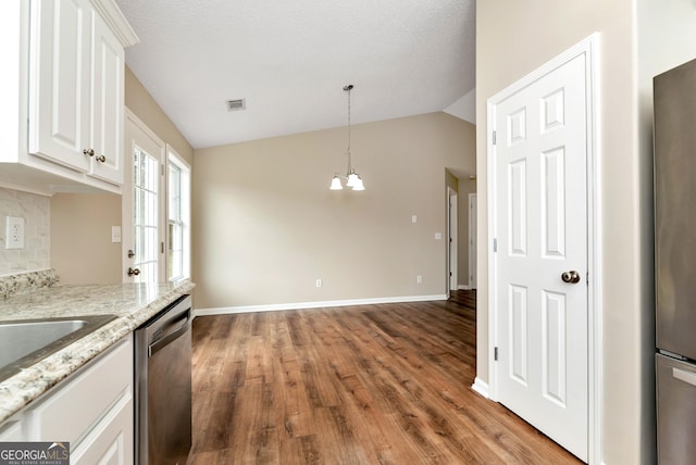 kitchen with visible vents, white cabinets, decorative backsplash, dishwasher, and vaulted ceiling