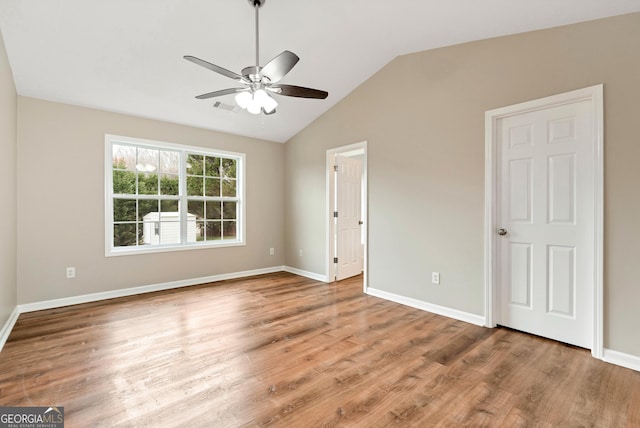 unfurnished bedroom with baseboards, visible vents, vaulted ceiling, and wood finished floors