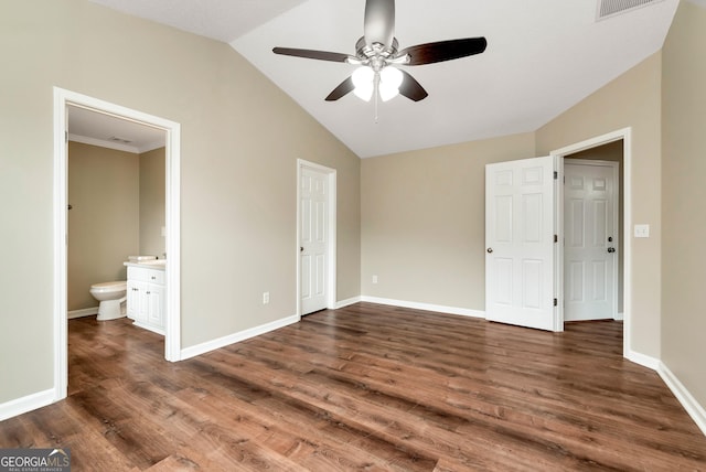 unfurnished bedroom featuring vaulted ceiling, ensuite bath, wood finished floors, and baseboards