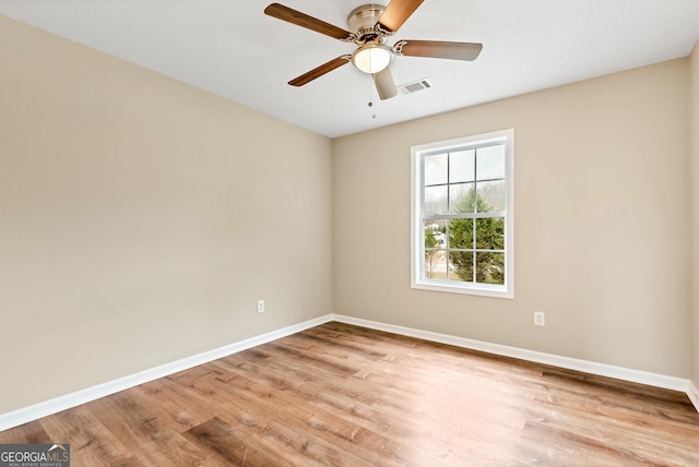 empty room with light wood-style floors, baseboards, visible vents, and a ceiling fan