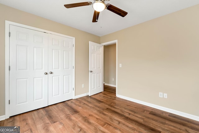 unfurnished bedroom featuring a closet, ceiling fan, baseboards, and wood finished floors