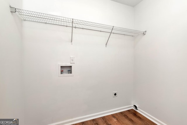 clothes washing area with washer hookup, electric dryer hookup, wood finished floors, laundry area, and baseboards