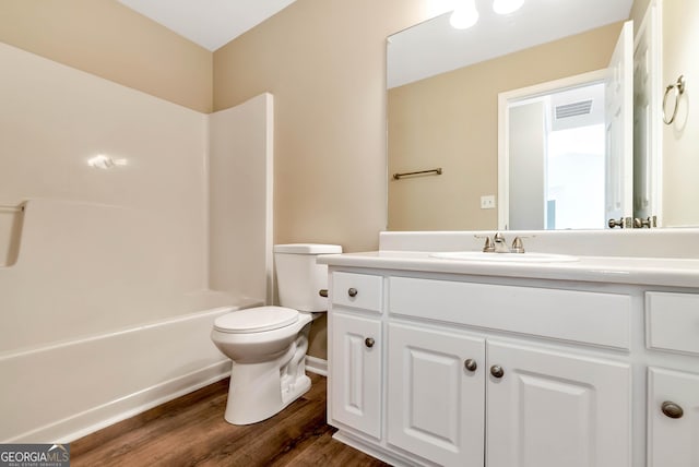 full bath featuring shower / bathtub combination, toilet, wood finished floors, visible vents, and vanity