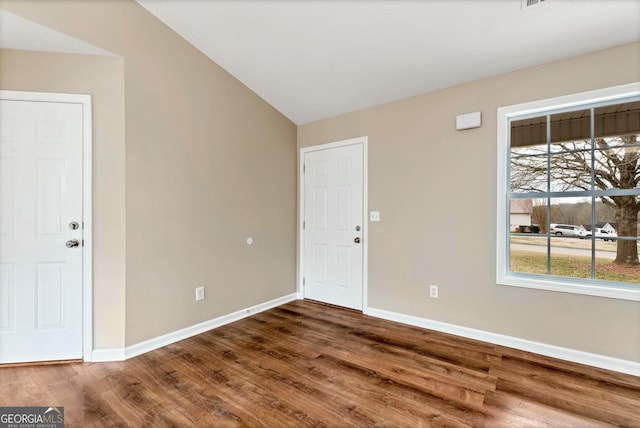 foyer entrance featuring vaulted ceiling, wood finished floors, and baseboards