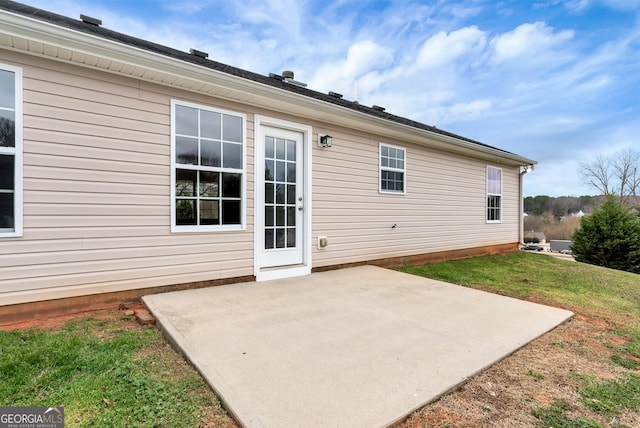 rear view of house featuring a patio and a lawn