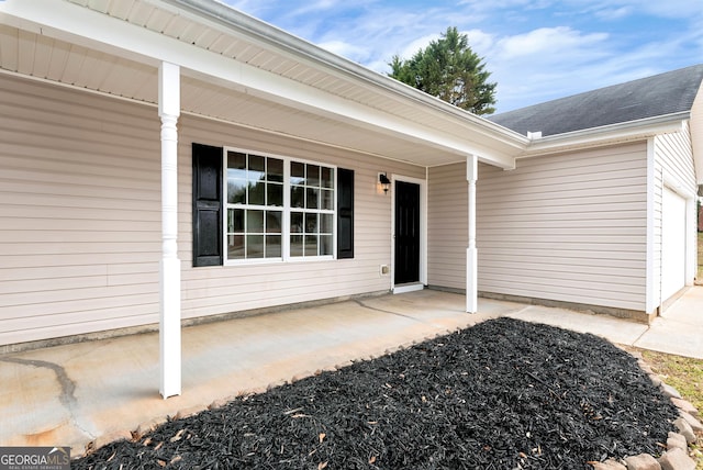 entrance to property featuring a shingled roof