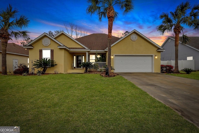 ranch-style home with driveway, stucco siding, an attached garage, covered porch, and a front yard