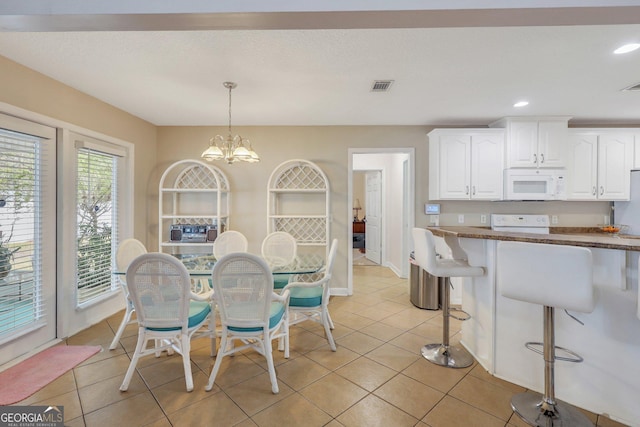 dining room with visible vents, a notable chandelier, light tile patterned flooring, and recessed lighting