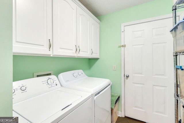 washroom with washer and dryer, cabinet space, tile patterned floors, and a textured ceiling