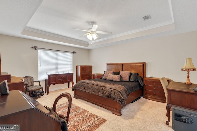 bedroom featuring ornamental molding, light carpet, and a tray ceiling