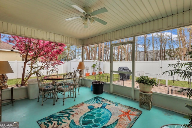 sunroom with outdoor dining space and a ceiling fan