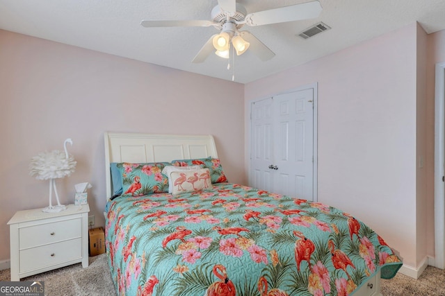 bedroom with light colored carpet, a ceiling fan, baseboards, visible vents, and a closet