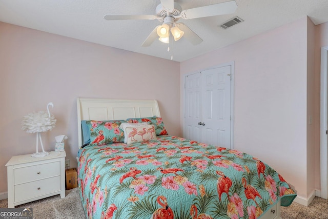 bedroom featuring a closet, ceiling fan, visible vents, baseboards, and light colored carpet