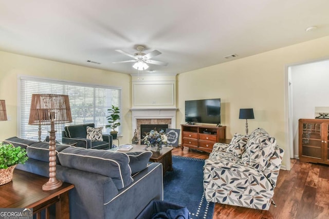 living area with dark wood-style floors, a premium fireplace, and visible vents