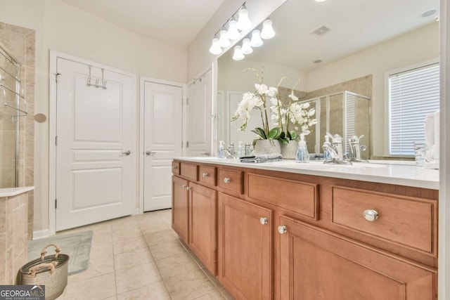 full bath with visible vents, a sink, a shower stall, and double vanity