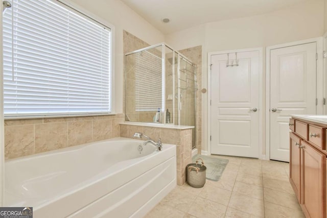 bathroom with a stall shower, tile patterned flooring, vanity, and a bath