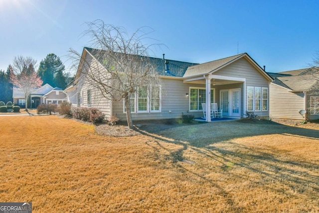 rear view of house with a yard and french doors