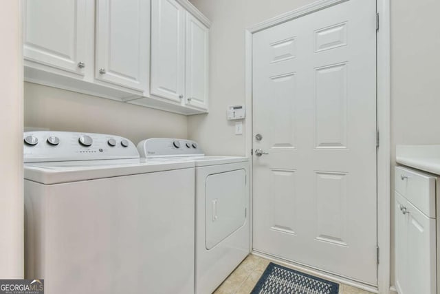 washroom featuring light tile patterned floors, washing machine and clothes dryer, and cabinet space