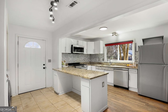 kitchen with tasteful backsplash, visible vents, appliances with stainless steel finishes, a peninsula, and white cabinetry