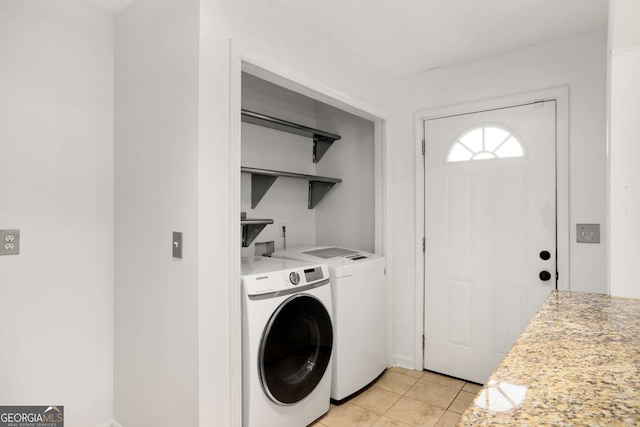 washroom featuring laundry area, separate washer and dryer, and light tile patterned flooring