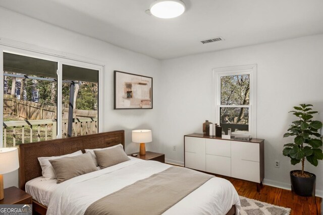 bedroom featuring wood finished floors, visible vents, and baseboards