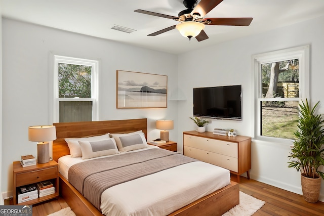 bedroom with a ceiling fan, visible vents, and light wood-style floors