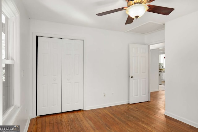 unfurnished bedroom with a closet, wood finished floors, and baseboards