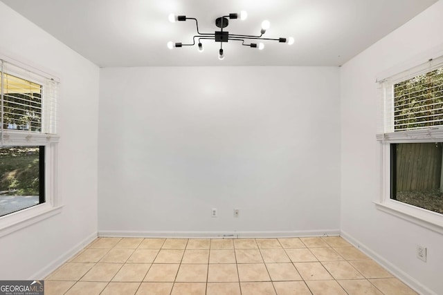 unfurnished room with light tile patterned floors and baseboards