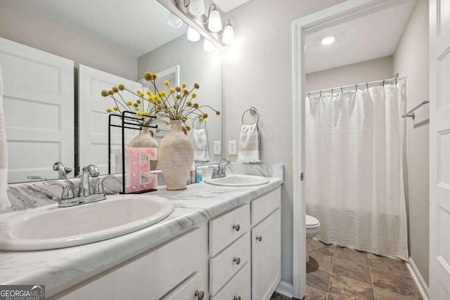 bathroom with double vanity, a shower with curtain, toilet, and a sink