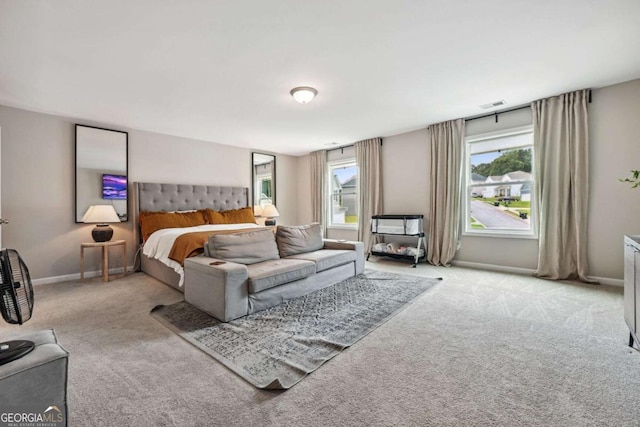 bedroom with carpet, visible vents, baseboards, and multiple windows