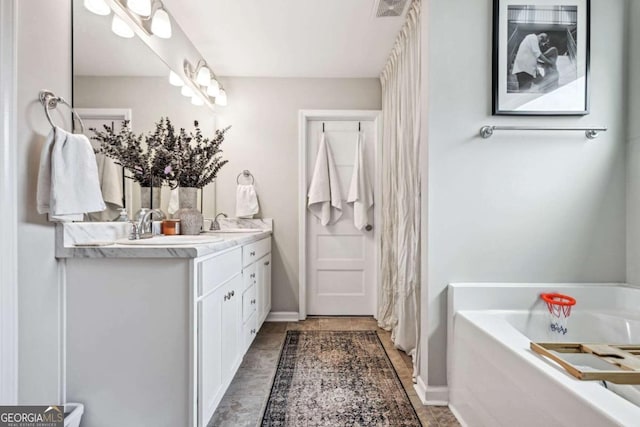 full bathroom with visible vents, a garden tub, a sink, and double vanity