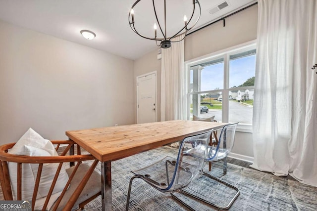 dining space featuring baseboards, visible vents, and a notable chandelier