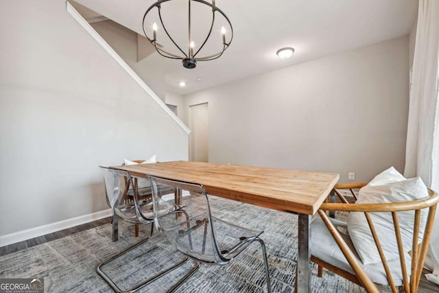 dining room with a notable chandelier, baseboards, and wood finished floors