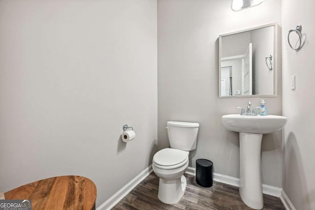 bathroom featuring wood finished floors, toilet, and baseboards