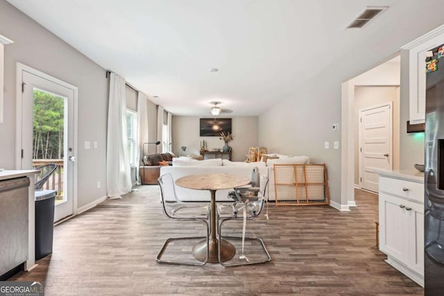 dining area with visible vents, dark wood finished floors, and baseboards