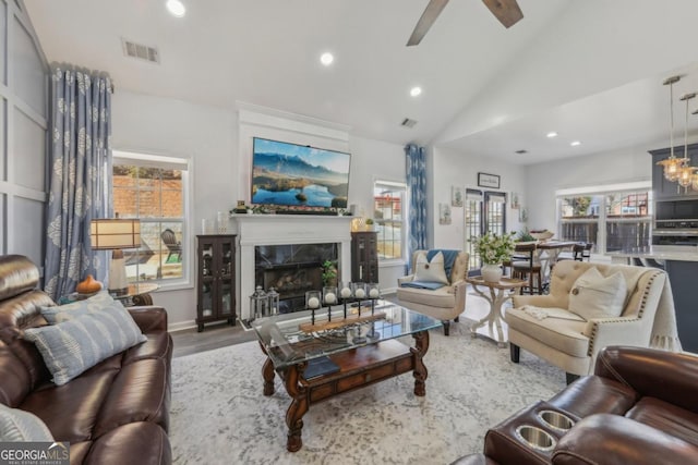 living room featuring recessed lighting, ceiling fan with notable chandelier, a premium fireplace, wood finished floors, and visible vents