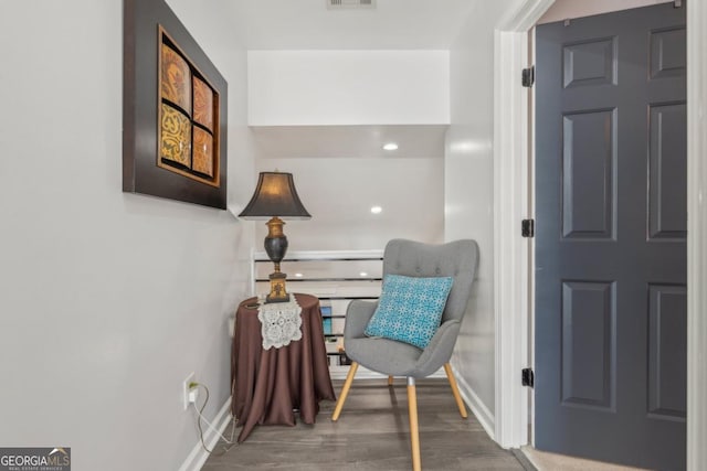 sitting room with visible vents, baseboards, and wood finished floors