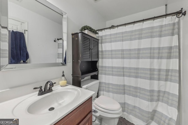 bathroom featuring toilet, a shower with shower curtain, and vanity