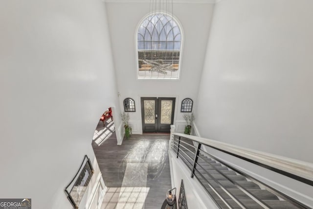 foyer entrance with french doors and a towering ceiling