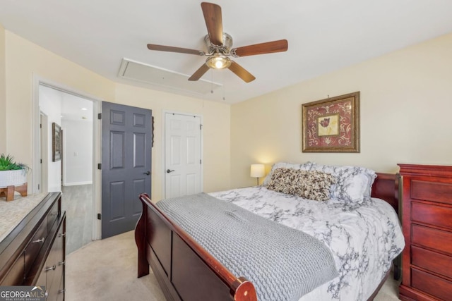 bedroom with light carpet, attic access, and a ceiling fan