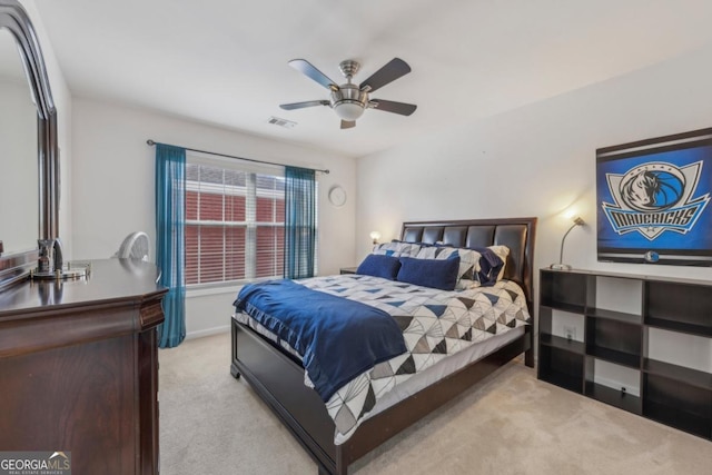 bedroom with light carpet, ceiling fan, and visible vents