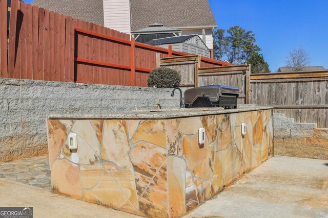 view of patio featuring fence and area for grilling