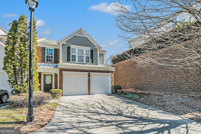 traditional-style home with a garage, concrete driveway, and brick siding