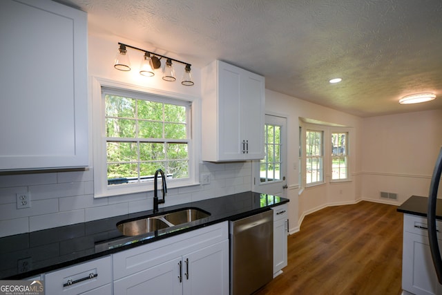 kitchen featuring tasteful backsplash, visible vents, a sink, white cabinetry, and stainless steel dishwasher