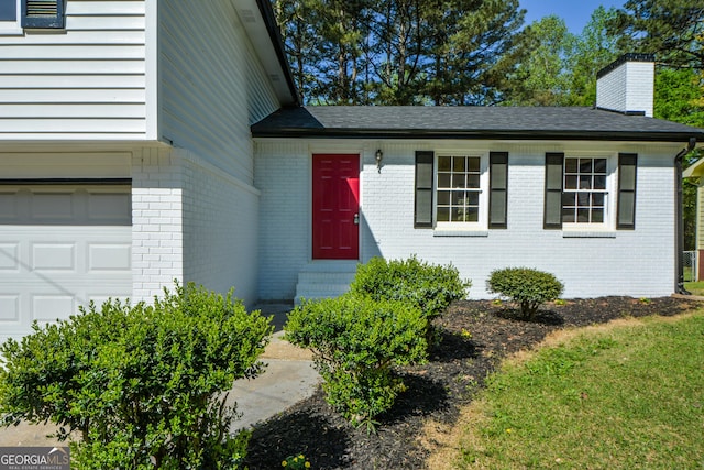 property entrance with a chimney and brick siding