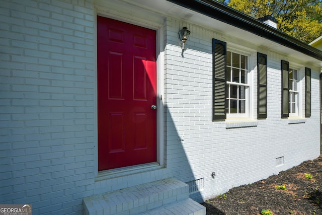 doorway to property with brick siding and crawl space